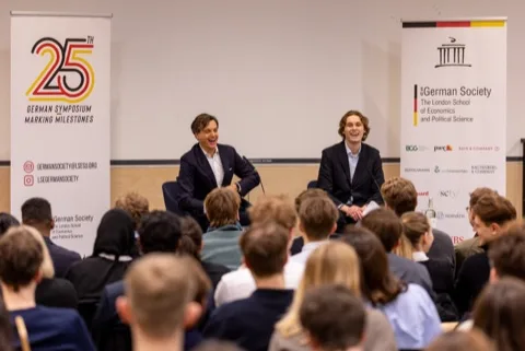 Josh de Buhr on stage with Philipp Freise at the LSE German Symposium 2026.