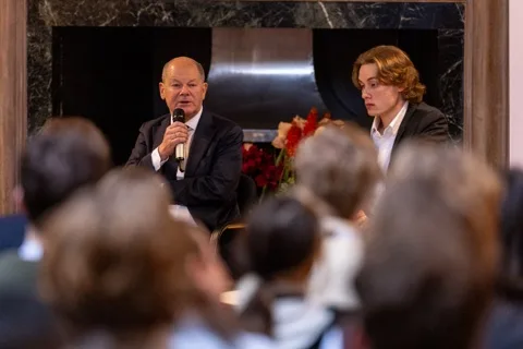 Josh de Buhr on stage with Olaf Scholz at the LSE German Symposium 2026.